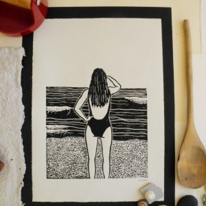 art print showing a women looking at the ocean and waves, in black and white