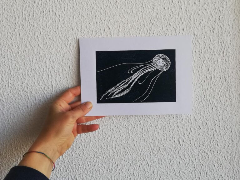 hand holds a print of a jellyfish
